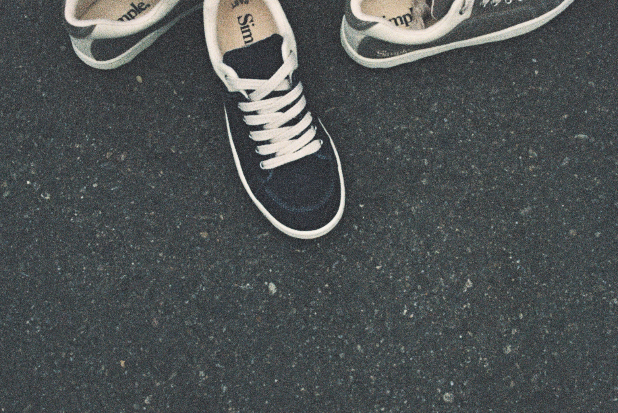 Black and white sneakers on a dark asphalt surface
